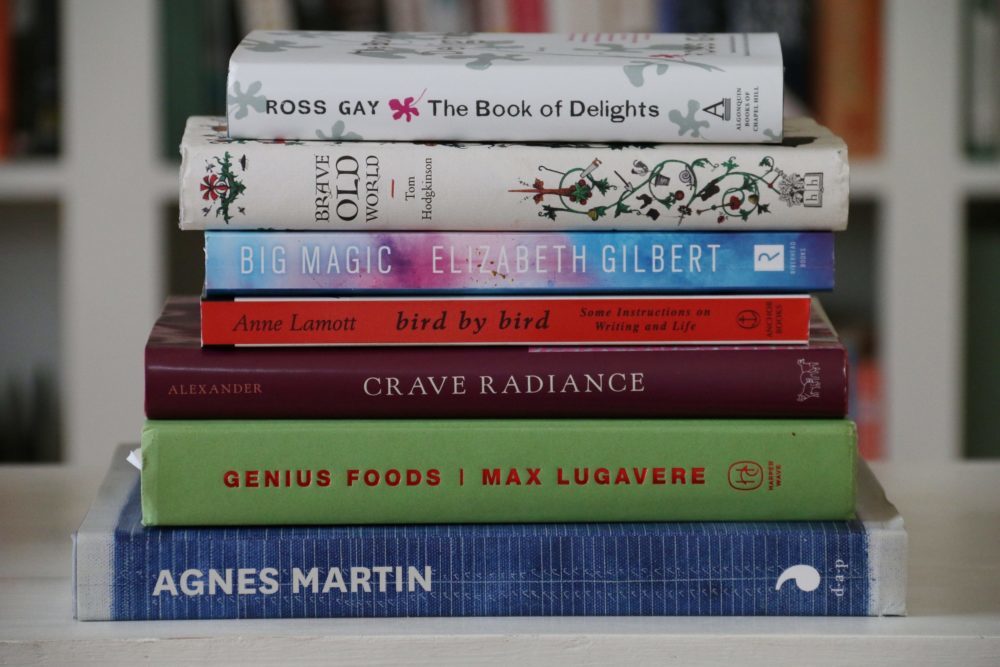 Alabama Chanin, stack of books: The Book of Delights, Brave Old World, Big Magic, Bird by Bird, Crave Radiance, Genius Foods, Agnes Martin