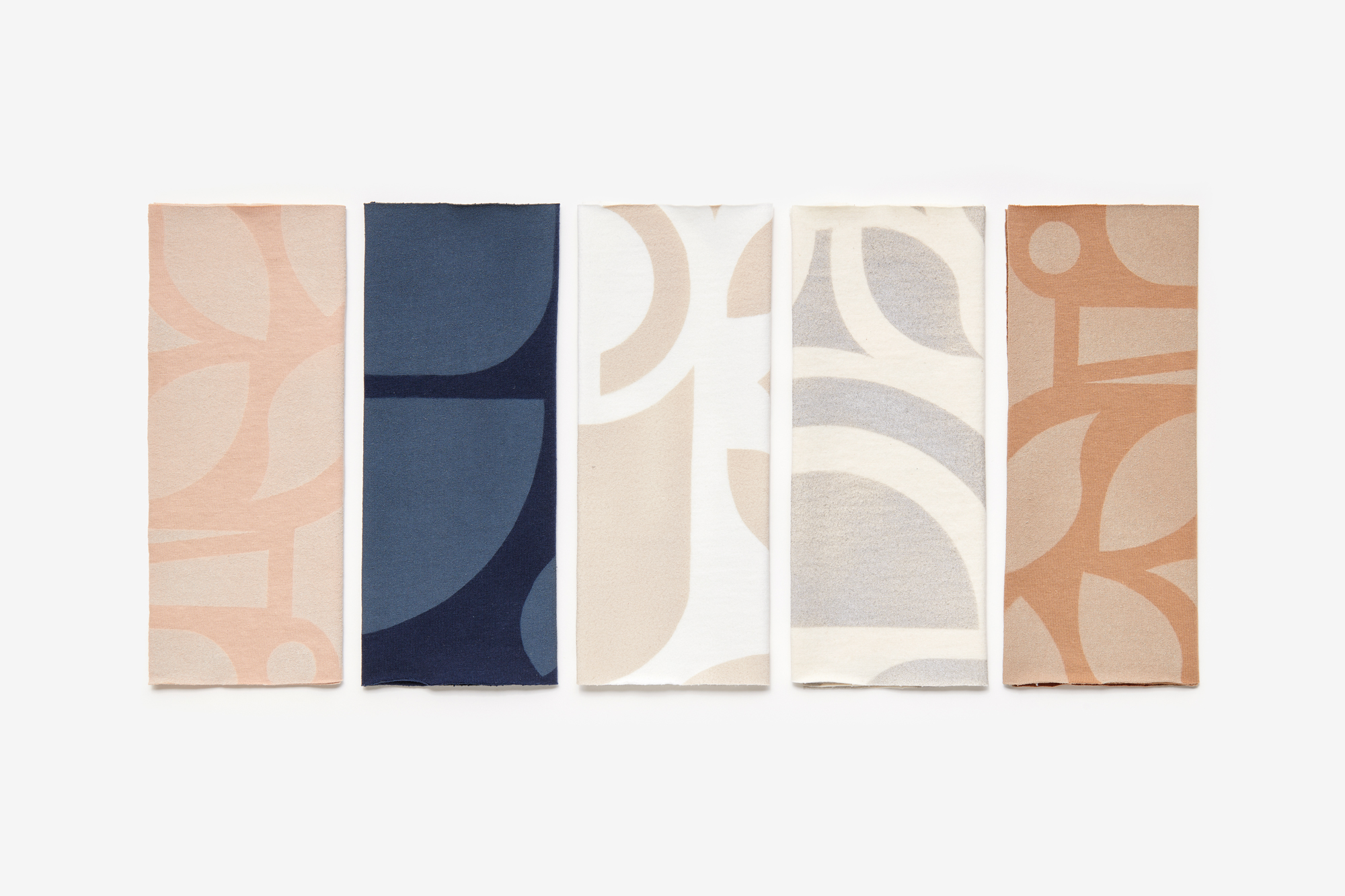 Fabric swatches in Ballet, Navy, White, Natural, and Camel, stenciled with the Abstract design.